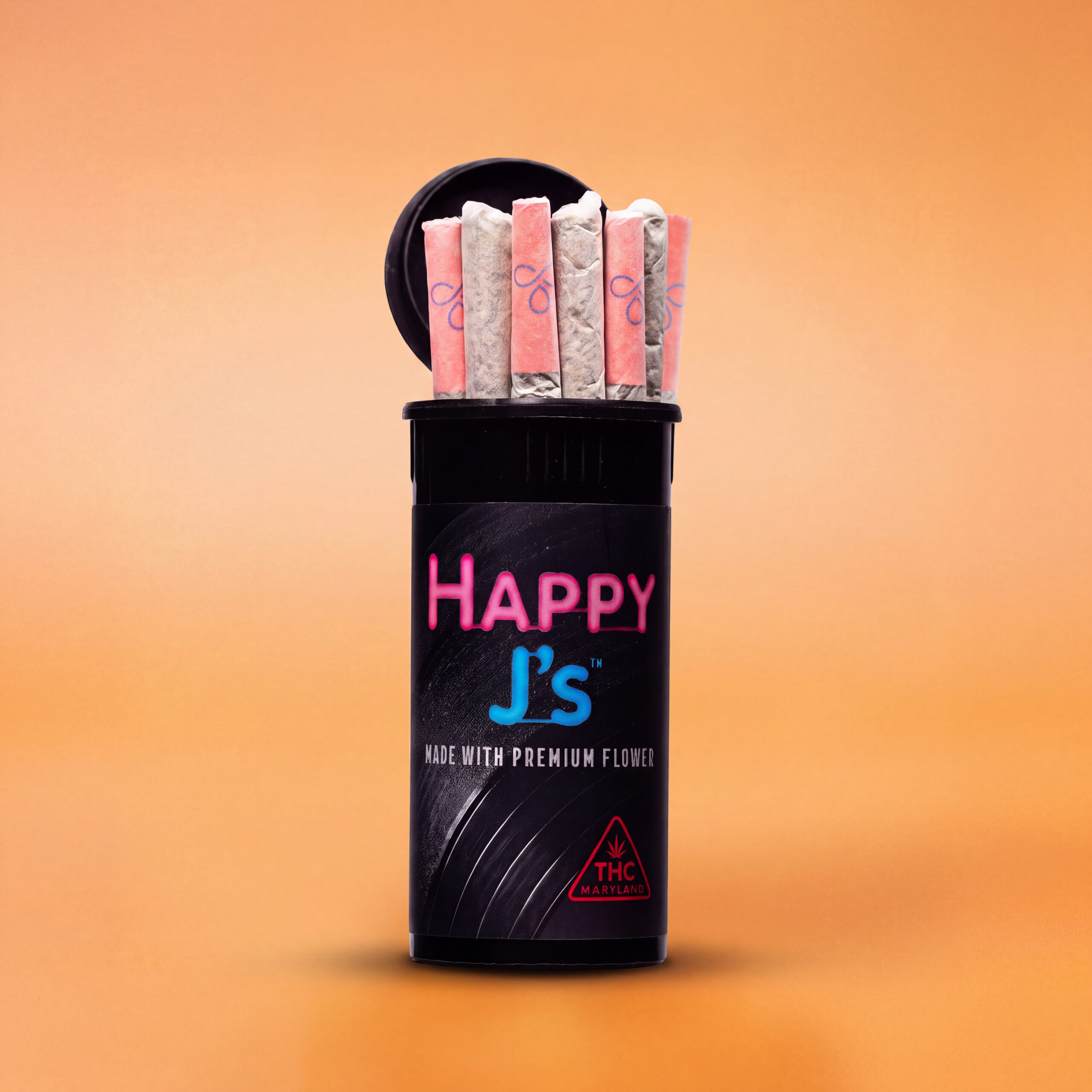 Black Happy J’s pop-top tube holding seven pre-rolls with pink and white tips against a solid orange background.