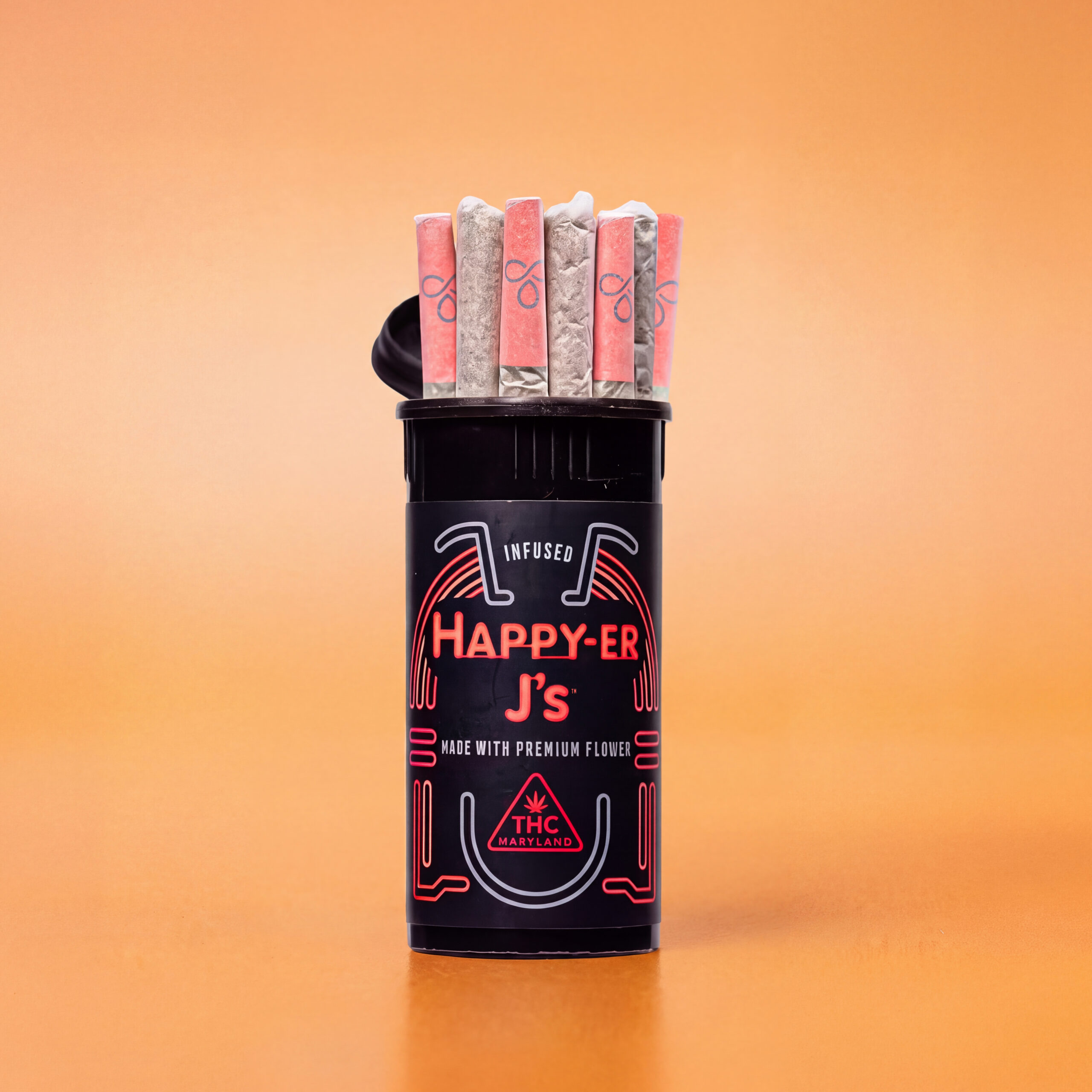 Black Happy-ER J’s pop-top tube holding seven pre-rolls with pink and white tips against a solid orange background.